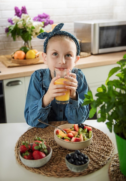 Menina bonitinha come salada de frutas