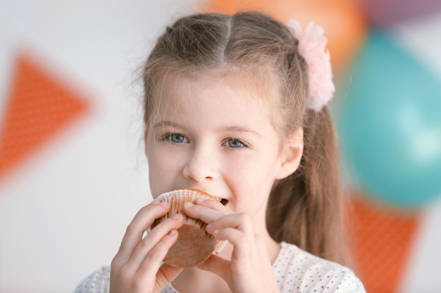 Menina bonitinha comendo bolinho saboroso vista de perto