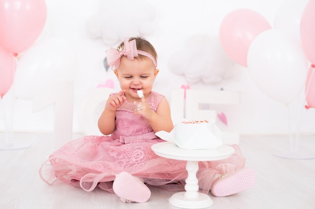 menina bonitinha comendo bolo de aniversário e comemorando seu primeiro aniversário