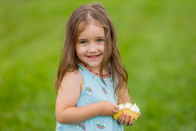 Menina bonitinha comendo bolo no parque aniversário feliz cartão saúde