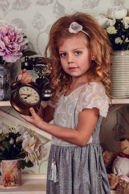 Menina bonitinha criança com flores da primavera