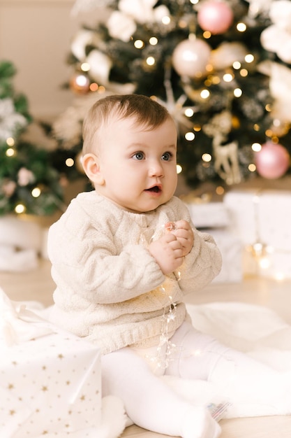 Menina bonitinha debaixo da árvore de natal boas festas feliz ano novo tempo de natal