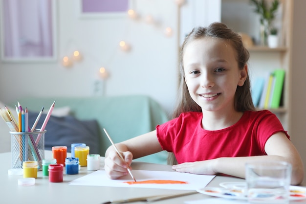 Menina bonitinha desenhando pinturas em casa