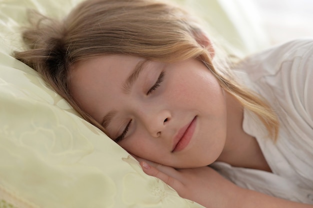 Menina bonitinha dormindo em uma cama