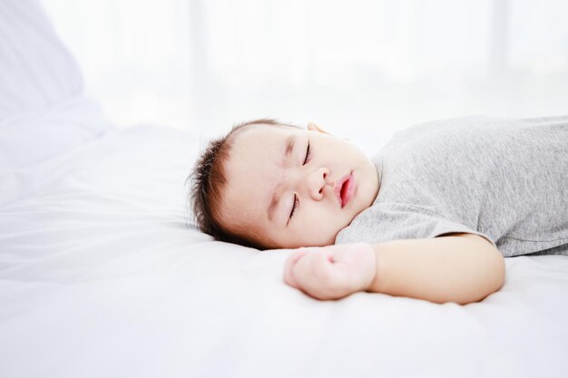 Menina bonitinha dormindo na cama Proteção de crianças