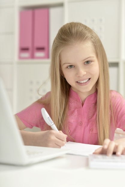 Menina bonitinha e laptop em casa