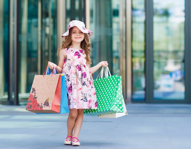 Menina bonitinha em compras, retrato de uma criança com sacos de compras, compras, menina.