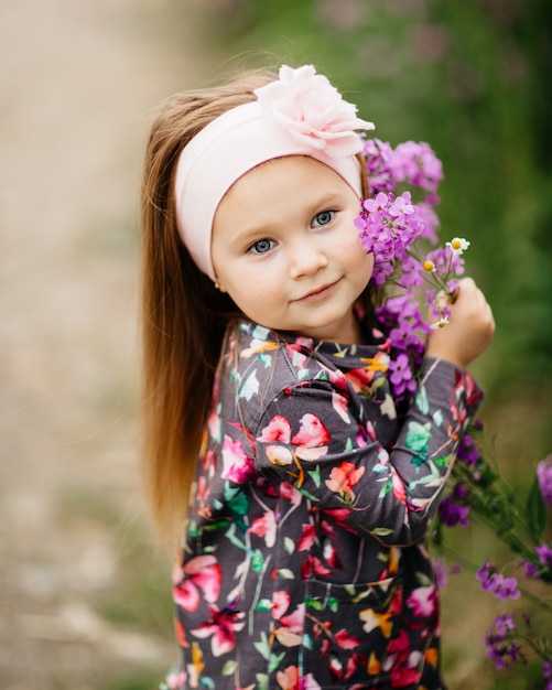Foto menina bonitinha em um jardim de flores