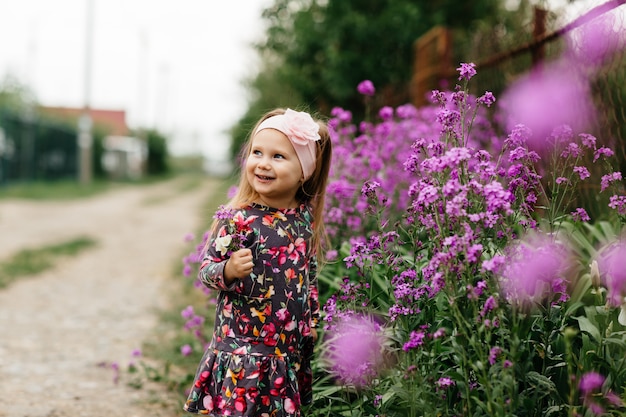 Foto menina bonitinha em um jardim de flores