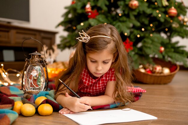 Menina bonitinha escrevendo carta para o Papai Noel