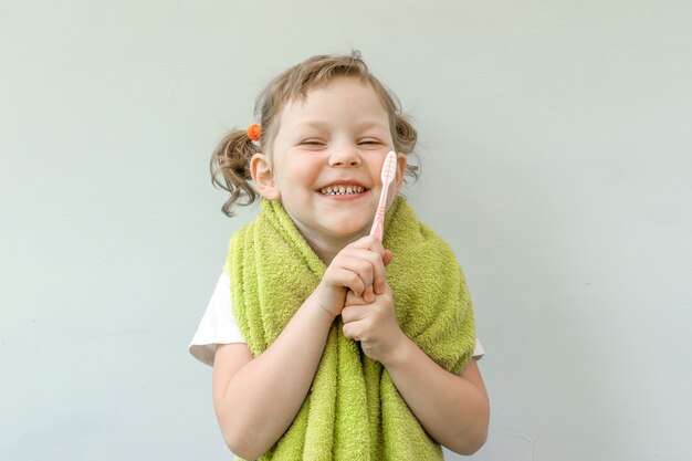 Menina bonitinha está escovando os dentes.