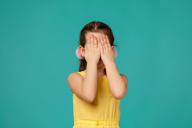 Menina bonitinha fecha os olhos com a mão