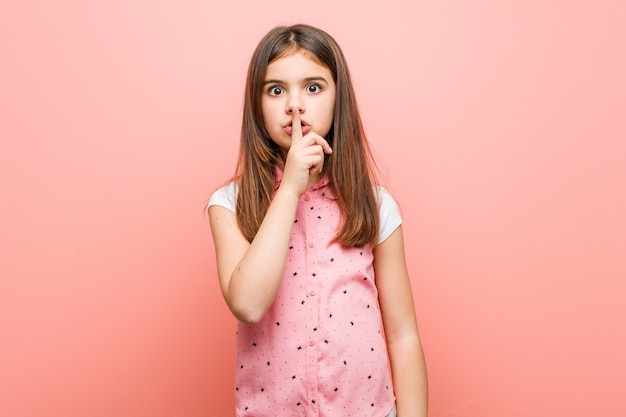 Menina bonitinha mantendo um segredo ou pedindo silêncio.