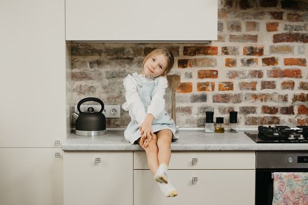 Menina bonitinha na bancada da cozinha