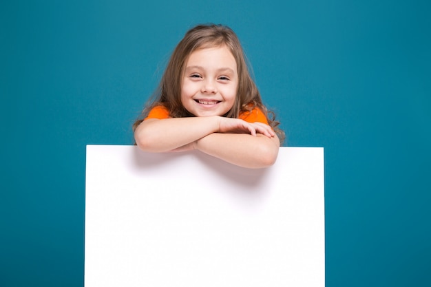 Menina bonitinha na camiseta com cabelo castanho segurar cartaz limpo