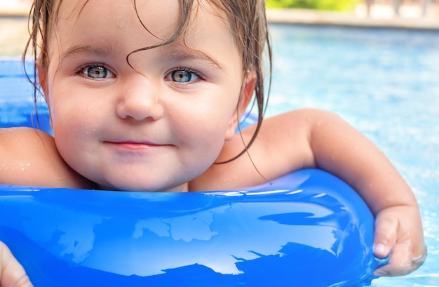 Menina bonitinha nada em um anel inflável na piscina