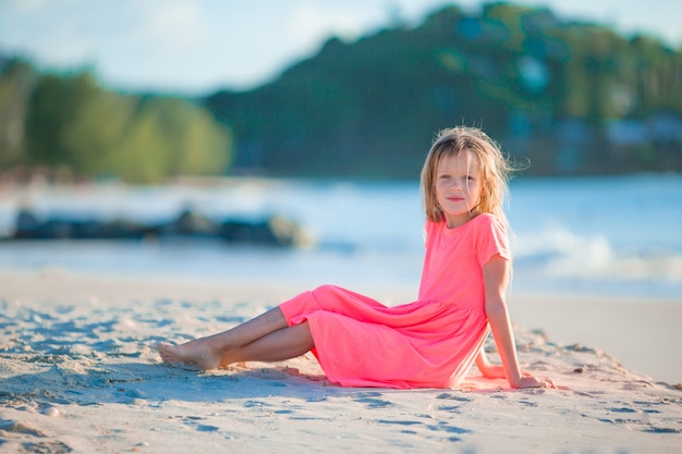 Menina bonitinha no chapéu na praia durante as férias do Caribe