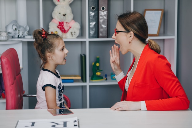 Menina bonitinha no escritório do fonoaudiólogo.