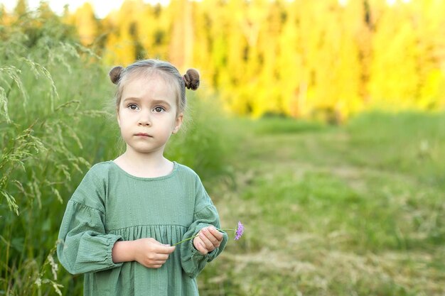 Menina bonitinha no prado em dia de primavera