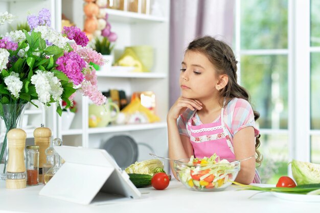 Menina bonitinha preparando salada fresca