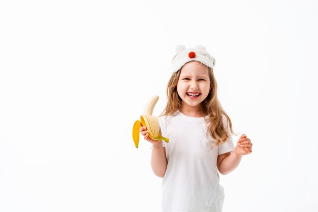 Menina bonitinha segurando banana na mão isolada