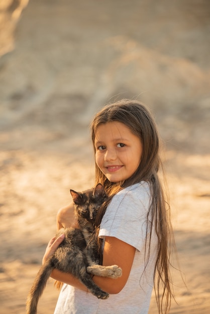 Menina bonitinha segurando um gato peludo