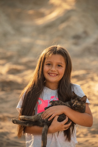 Menina bonitinha segurando um gato peludo