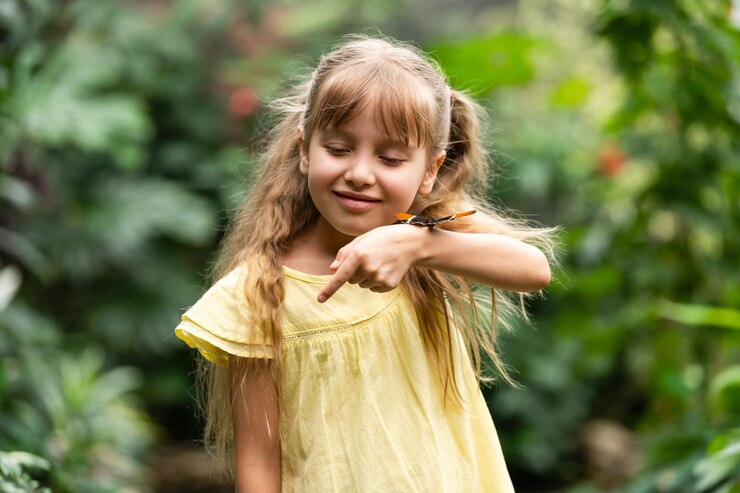 Foto menina bonitinha segurando uma linda borboleta viva na mão