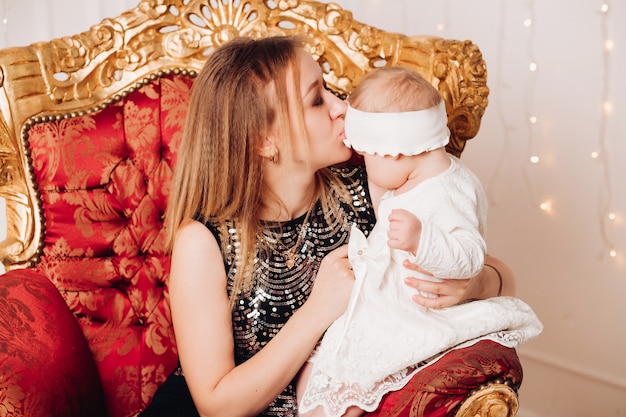 Menina bonitinha sentada com a mãe. época de natal.