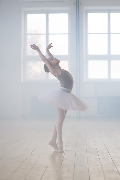 Menina bonitinha sonhando em se tornar dançarina de balé profissional em uma escola de dança clássica