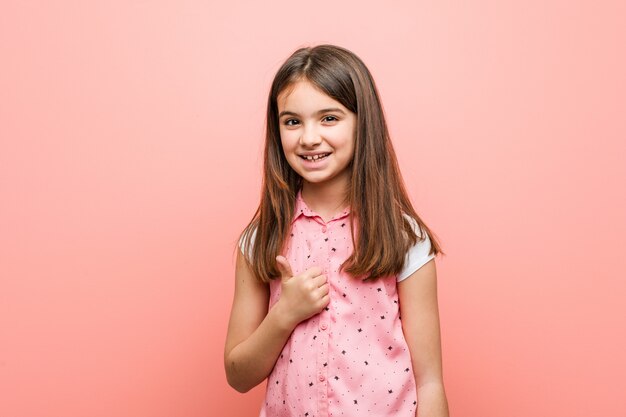 Foto menina bonitinha sorrindo e levantando o polegar