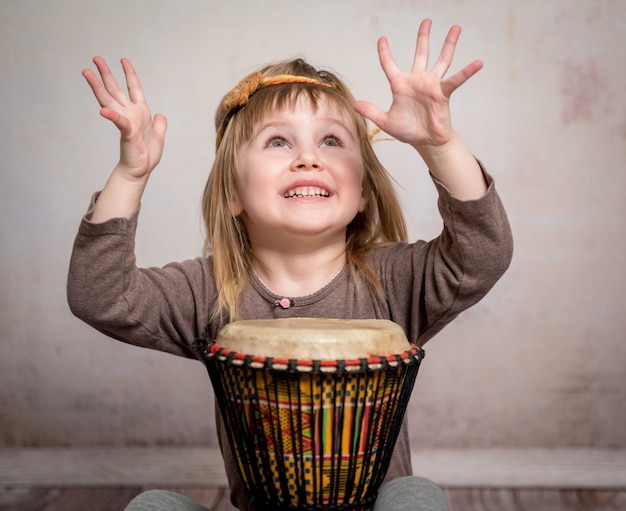 Menina bonitinha tocando tambor