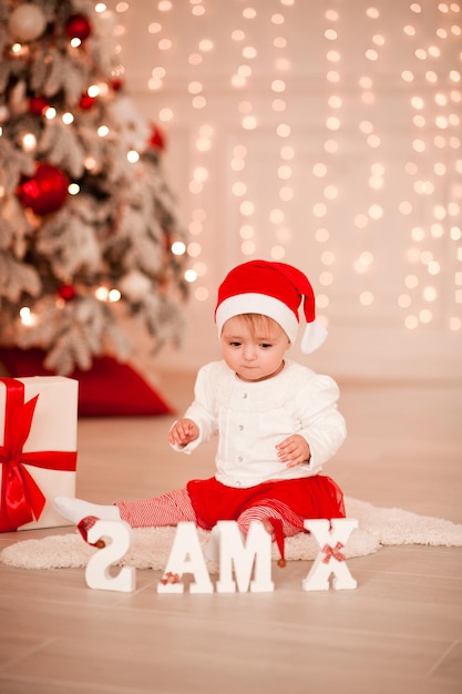 Menina bonito com decorações de Natal na sala. Temporada de férias. Infância.