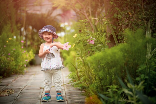 Menina bonito pequena feliz no jardim.