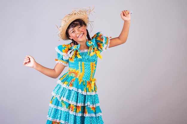 Menina brasileira com roupas de Festa Junina dançando