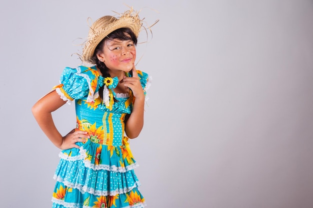 Menina brasileira em roupas de festa junina pensando