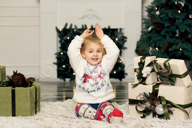 Menina brinca com decorações de pinhas para a árvore de Natal.