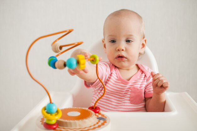 menina brinca com um brinquedo educacional do labirinto. Desenvolvimento de habilidades motoras finas e lógicas