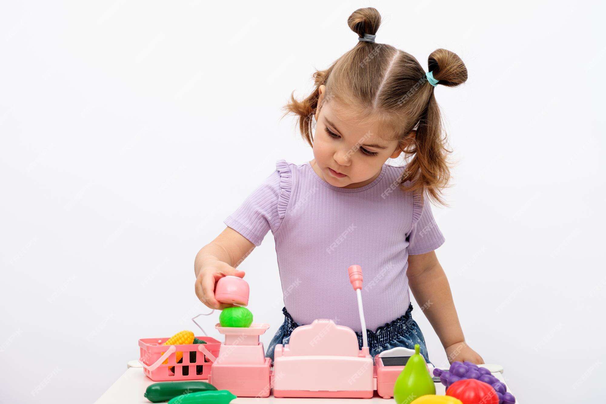 Menina loira brinca na loja pesa milho em balanças de brinquedo coleta  pedido em pacote de artesanato caixa registradora infantil jogos caseiros  para crianças comida online pedidos entrega de comida