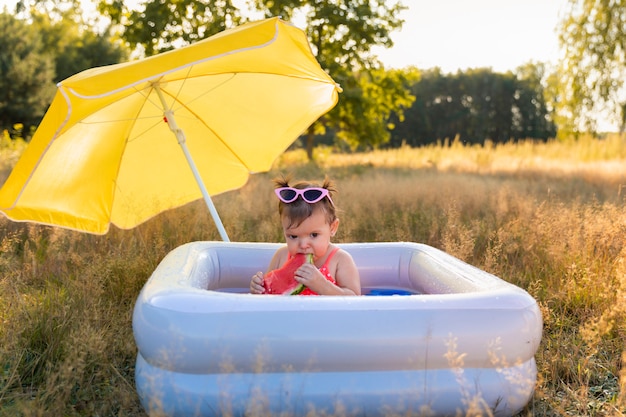 Menina brinca na piscina inflável.