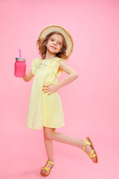 Menina brincalhão em roupa de verão com bebida