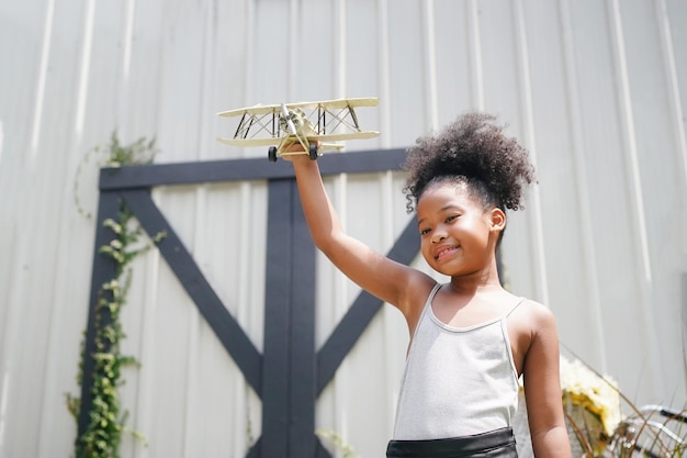 Menina brincando com avião de brinquedo