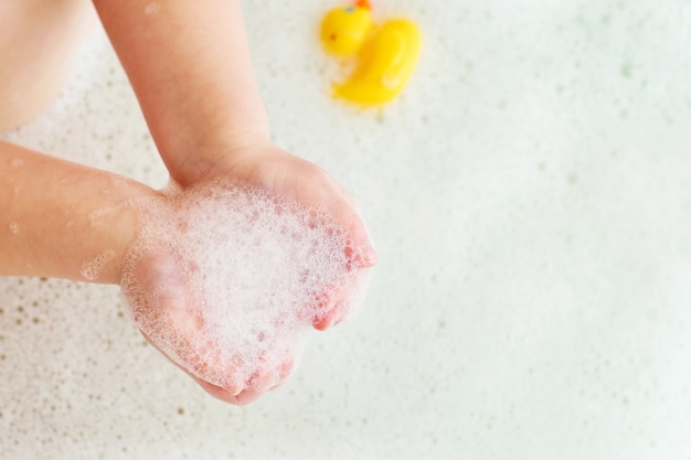 menina brincando com espuma na banheira