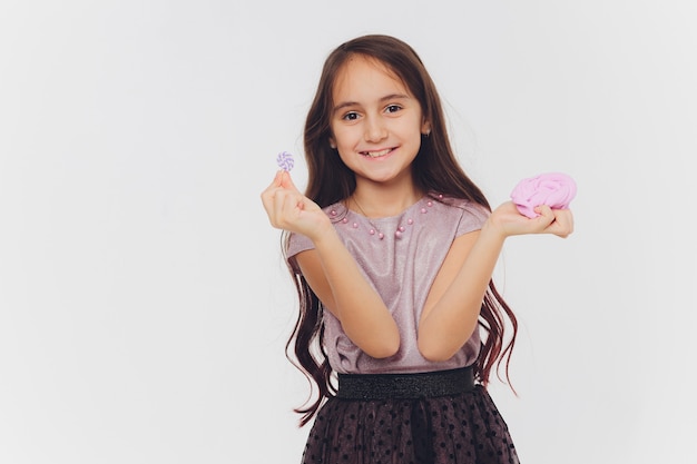 Menina brincando com lodo. Isolado no fundo branco