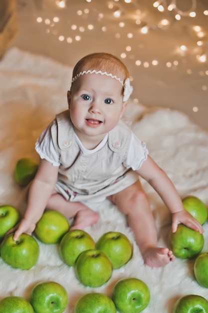 Menina brincando com maçãs verdes