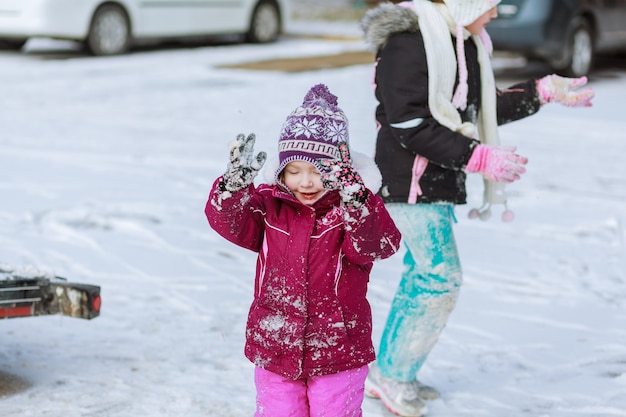 Menina brincando com neve no inverno, atividades infantis