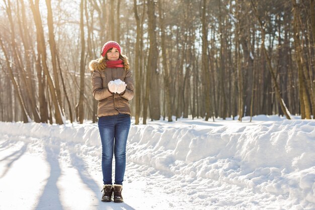 Menina brincando com neve no parque. Inverno