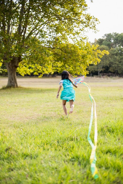 Menina brincando com pipa no parque