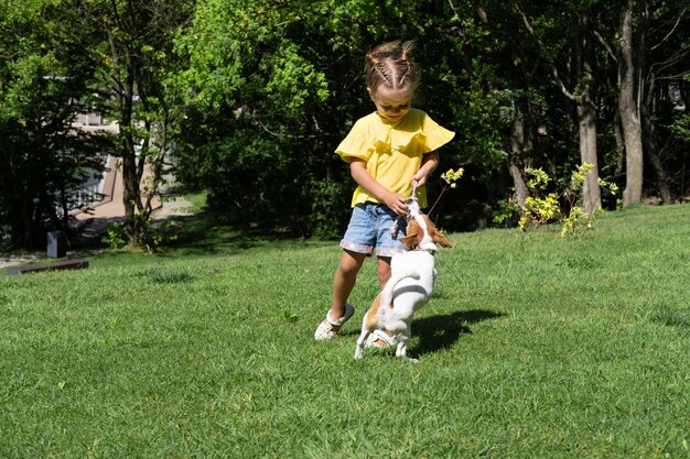 Menina brincando com seu cachorro de estimação jack russell terrier no parque