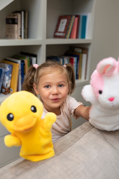 Foto menina brincando com seus fantoches em casa